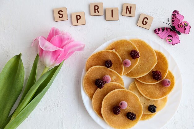 Pannenkoeken bloemen en lente inscriptie op een witte achtergrond