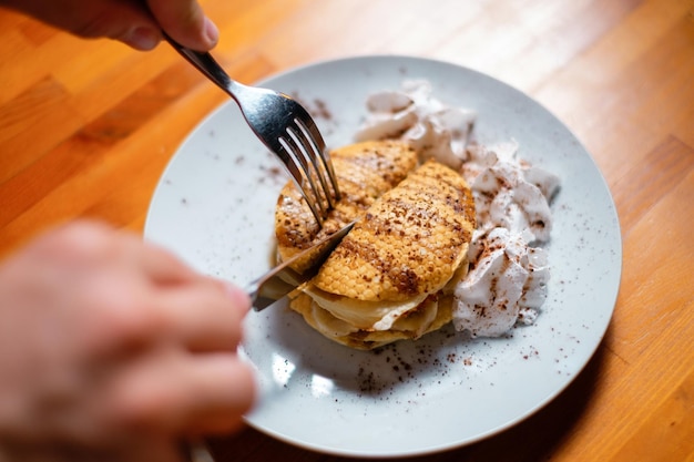 Pannenkoeken eten met honing met mes en vork gezond en voedzaam ontbijt