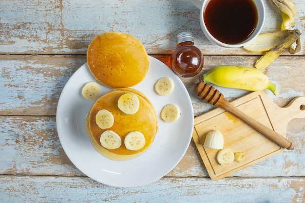 Pannenkoeken gegarneerd met honing en bananen op tafel