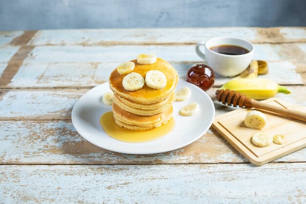 Pannenkoeken gegarneerd met honing en bananen op tafel