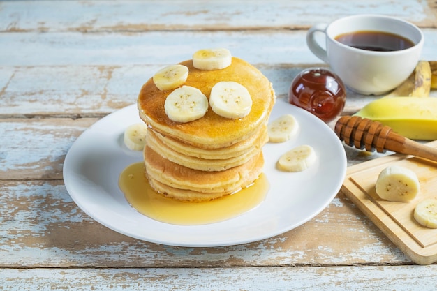 Pannenkoeken gegarneerd met honing en bananen op tafel