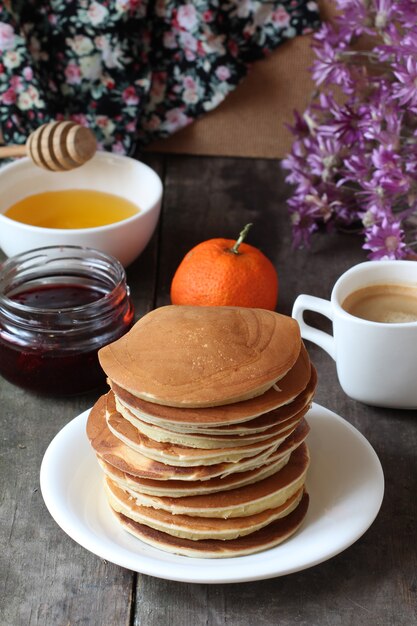 Pannenkoeken in een bord op een houten tafel met honing