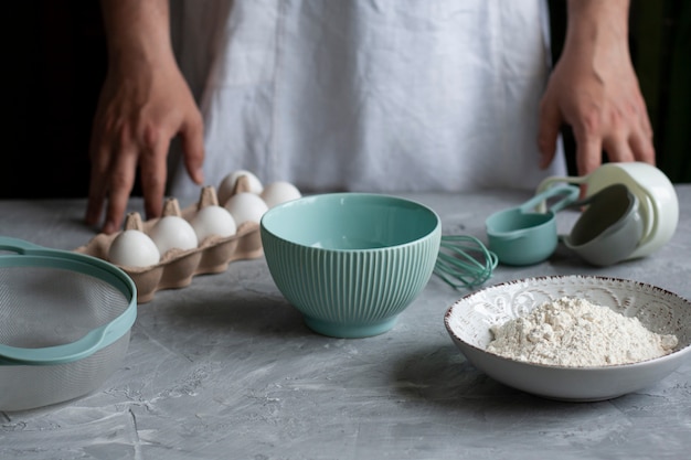 Pannenkoeken maken met chef. Chef-kok op zijn werkplek met koken inventaris en ingrediënten op een donkere