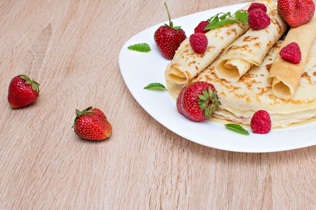 Foto pannenkoeken met aardbeien en frambozen op een bord