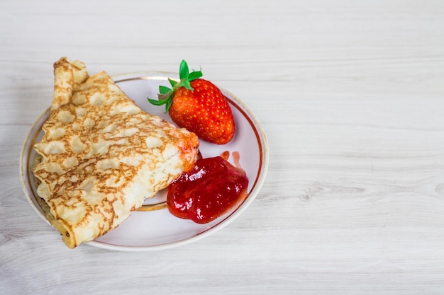 Pannenkoeken met aardbeien op een houten ondergrond