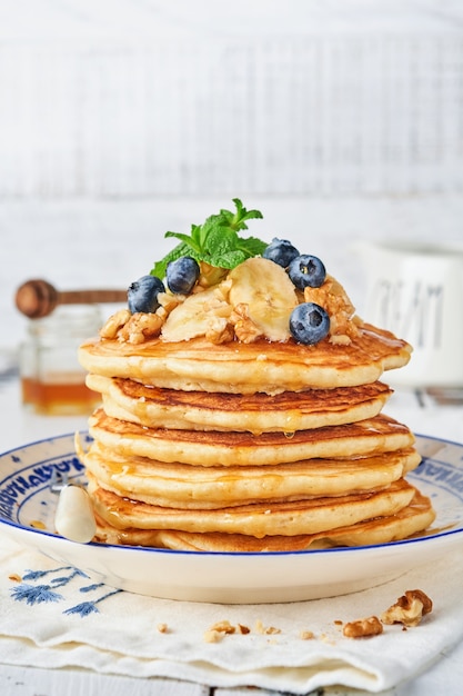 Pannenkoeken met banaan, walnoot, honing en karamel als ontbijt. Selectieve aandacht.