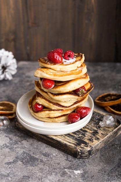 Pannenkoeken met bessen op witte steen achtergrond, kerst Dessert. Pannekoeken. Stapel pannenkoeken