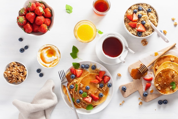 Pannenkoeken met bosbessen aardbeien honing en quinoa voor het ontbijt