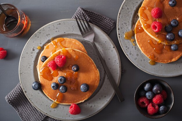 Pannenkoeken met bosbessen frambozen honing en jam voor het ontbijt