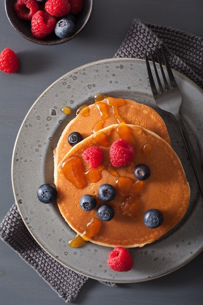 Pannenkoeken met bosbessen frambozen honing en jam voor het ontbijt