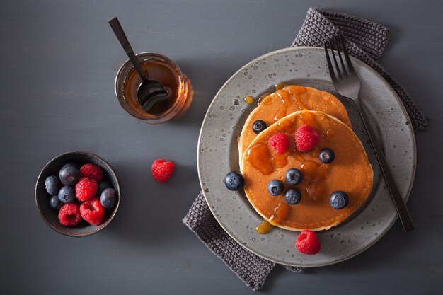 Pannenkoeken met bosbessen frambozen honing en jam voor het ontbijt