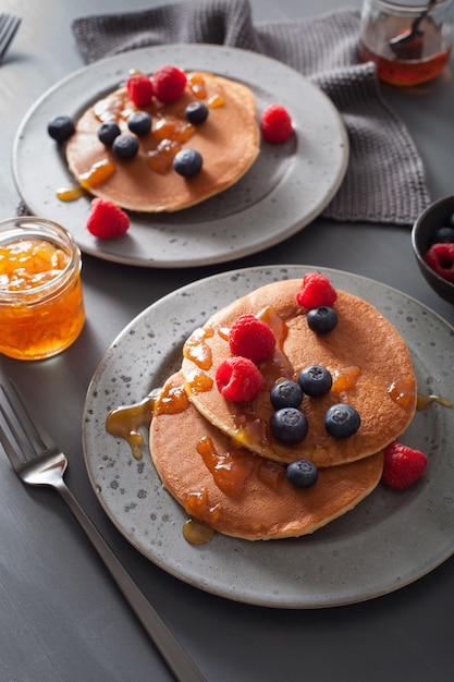 Pannenkoeken met bosbessen frambozen honing en jam voor het ontbijt