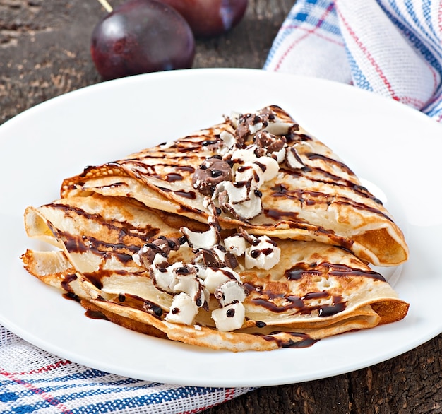 Pannenkoeken met chocoladesiroop en pruimen