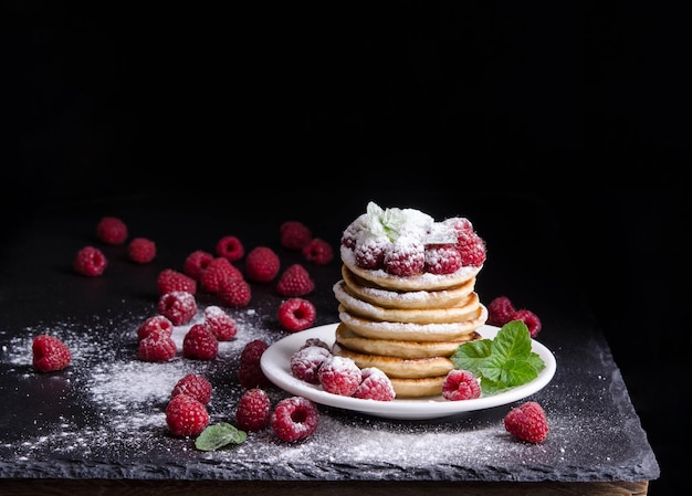 Pannenkoeken met frambozen rond op zwarte achtergrondkleur