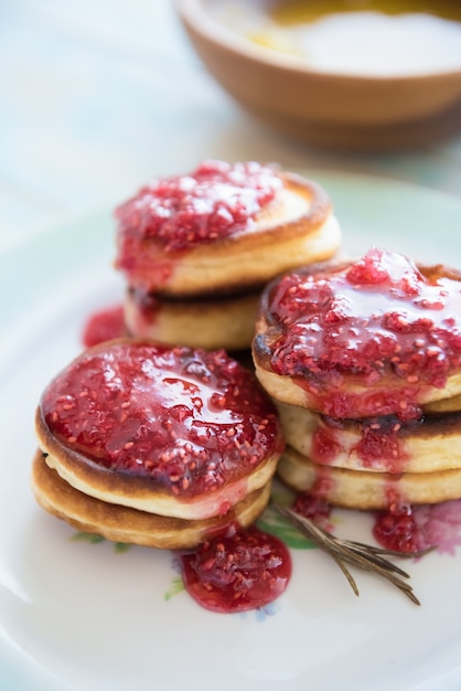 Pannenkoeken met frambozenjam op plaat op houten lijst