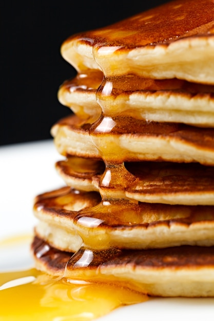 Pannenkoeken met honing en veenbessen op een bord.