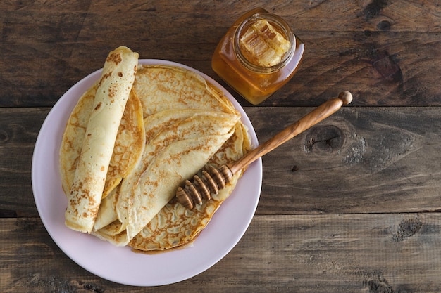 Pannenkoeken met honing op een houten achtergrond kopie ruimte