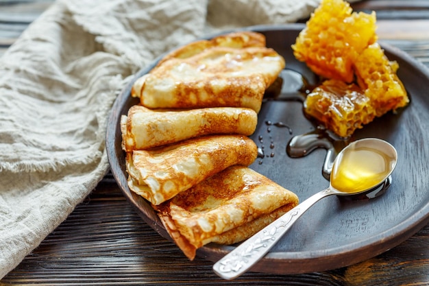 Pannenkoeken met honing op een houten plaat