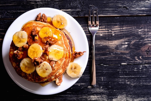 Pannenkoeken met honing van de banaanwalnoot op houten achtergrond