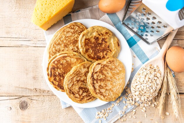 Pannenkoeken met kaas op donkere houten tafel.