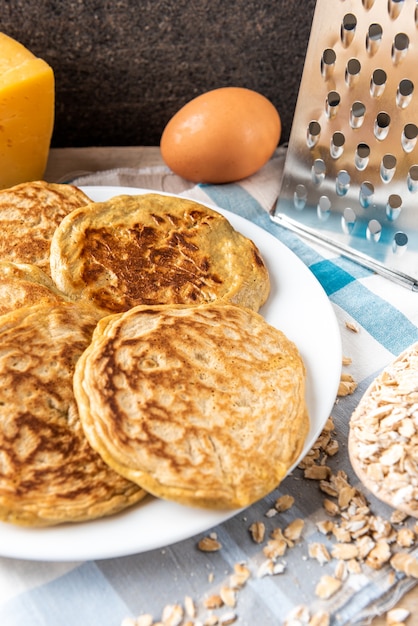 Pannenkoeken met kaas op donkere houten tafel.