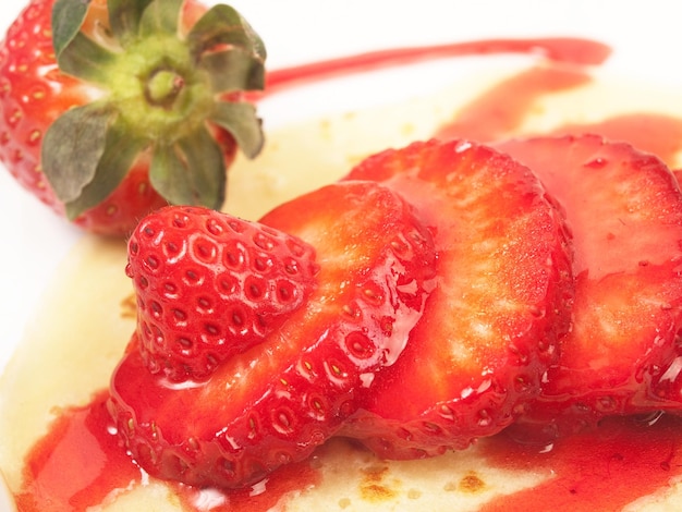 Pannenkoeken met plakjes aardbei en siroop in een close-up weergave