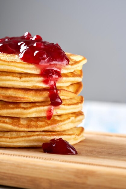 Pannenkoeken met rode bessenjam op de houten tafel