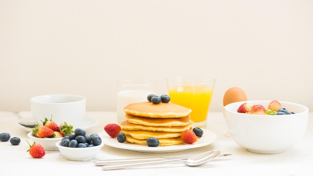Pannenkoeken met sapglas op tafel tegen een witte achtergrond