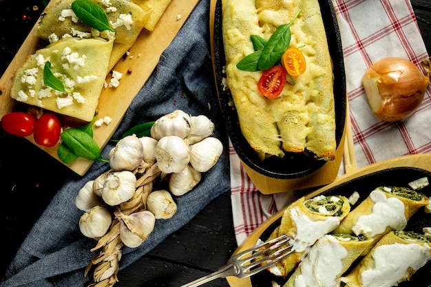 Foto pannenkoeken met spinazie op de snijplank, zwarte tafel en bovenaanzicht