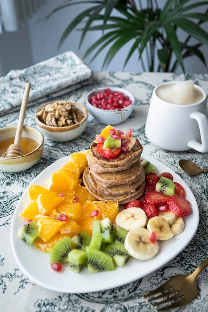 Pannenkoeken met vers fruit. Fruitsalade met glutenvrije pannenkoeken. Gezond ontbijt vol vitaminen