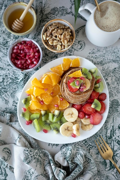 Pannenkoeken met vers fruit. Fruitsalade met glutenvrije pannenkoeken. Gezond ontbijt vol vitaminen