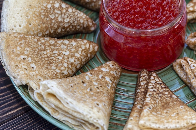 Pannenkoeken op een bord met een pot rode kaviaar Maslenitsa vakantie pannenkoeken week traditioneel slavisch