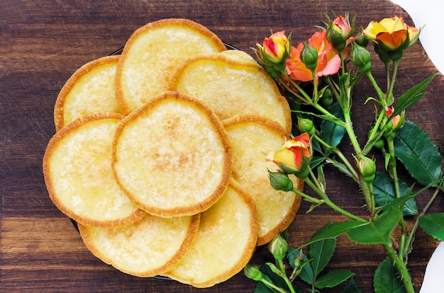 Pannenkoeken op een houten bord met een roze bloem