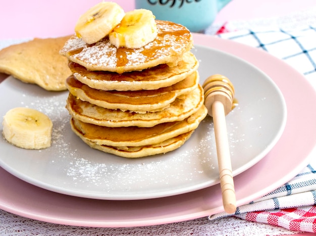 Pannenkoekenglijbaan met honingtopping en verse bananen zelfgemaakte bananenpannenkoekjes op bord