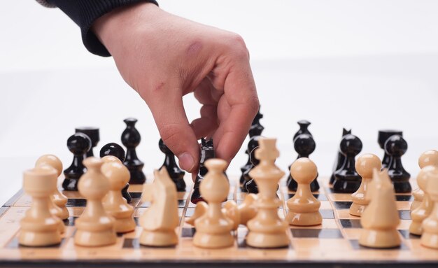 Panning shot of a chess board with a hand moving the chess pieces.