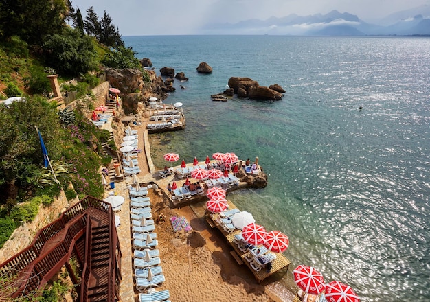 Panorama of Antalya coast from the tall cliff with Mermerli beach Pier of old port modern hotels and Taurus mountains on background