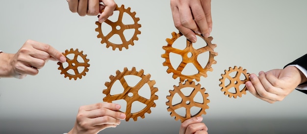 Foto panorama-banner van een zakelijk team dat zich met een tandwiel in een cirkel verbindt, symboliseert een succesvolle groep van zakelijk partnerschap en sterke collectieve teamwork-eenheid op de werkplek met productieve efficiëntie schrander