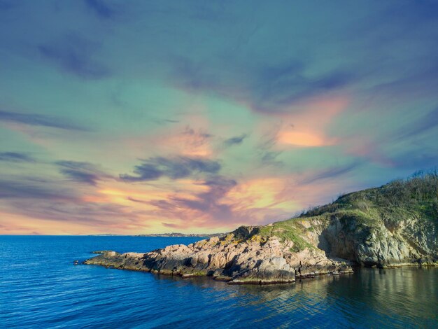 Foto panorama di una spiaggia con sabbia e pietre vicino al mar nero sotto la luce del tramonto in bulgaria