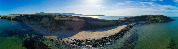 Панорама пляжа с песком и камнями у Черного моря под закатным светом в Болгарии