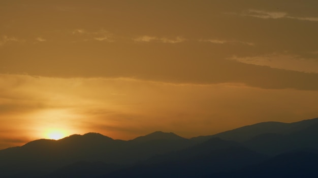 Panorama berglandschap met zon die door bergtoppen schijnt in realtime