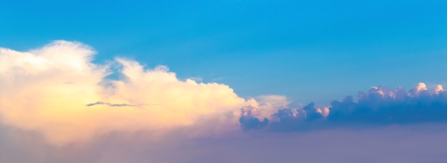 夕暮れ時の明るい雲と暗い雲のある青い空のパノラマ