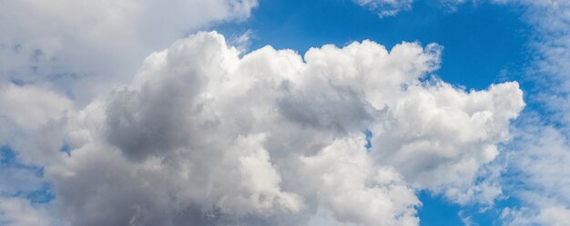 Panorama of blue sky with thick white curly clouds