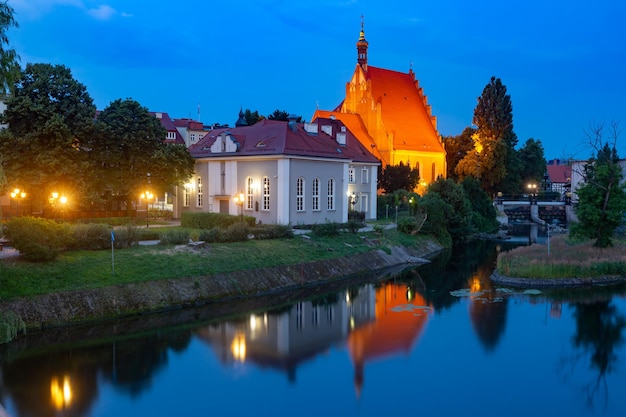Panorama della cattedrale gotica di bydgoszcz in mattoni con riflesso nel fiume brda di notte bydgoszcz polonia