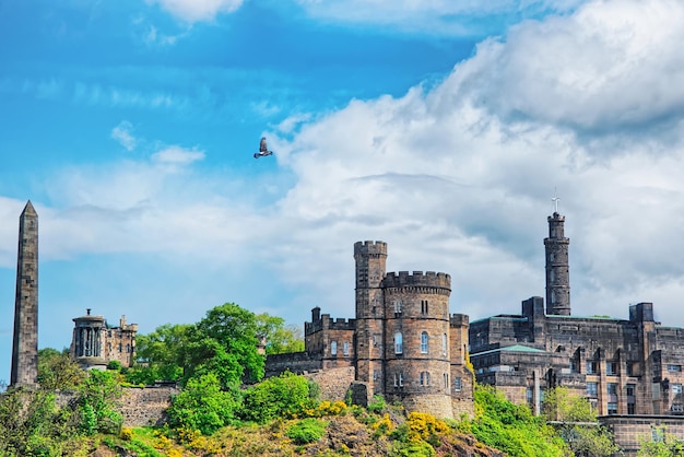 Photo panorama of calton hill with political martyrs monument on old calton burial ground, dugald stewart monument, st andrew house and tower of nelson monument in edinburgh in scotland.