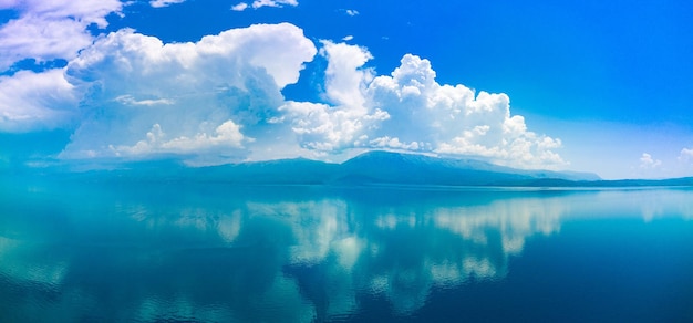 雲のパノラマが地平線上の昼間の空を横切って浮かび、アドリア海が光ります