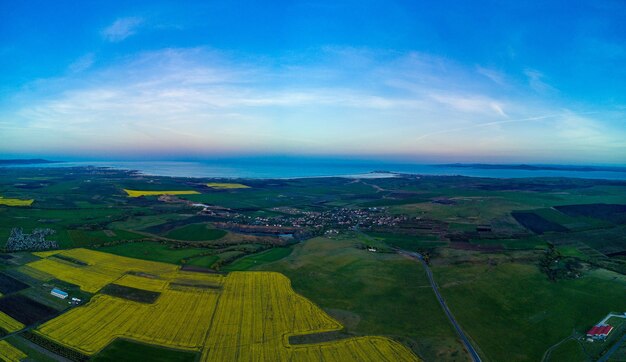 Photo panorama of the fields with a plant in a valley against the background of the village and the sky in bulgaria