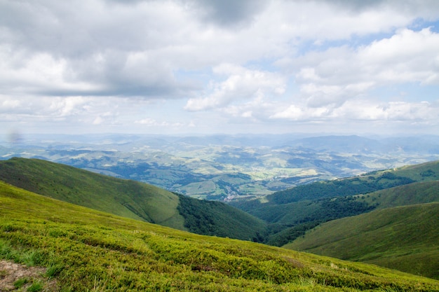 Панорама зеленых гор с облаками и деревня