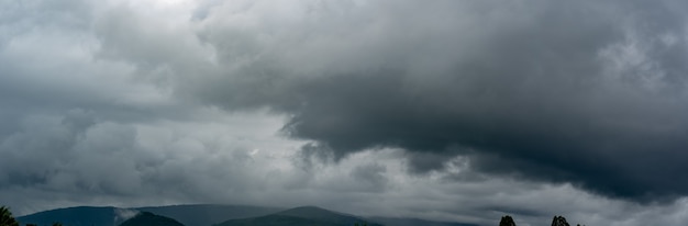 Фото Панорама тяжелые облака штормовой дождь на небе над рисовым полем в сельской местности облако дождя над холмом