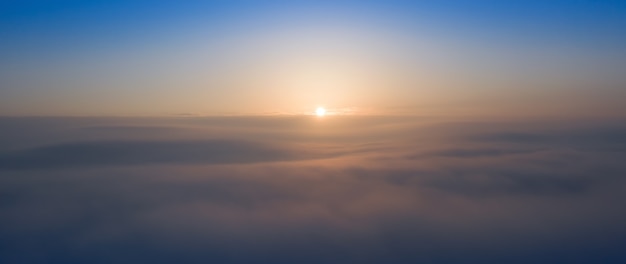 Panorama of the morning blue sky, illuminated by orange and red sunlight, colorful dawn.