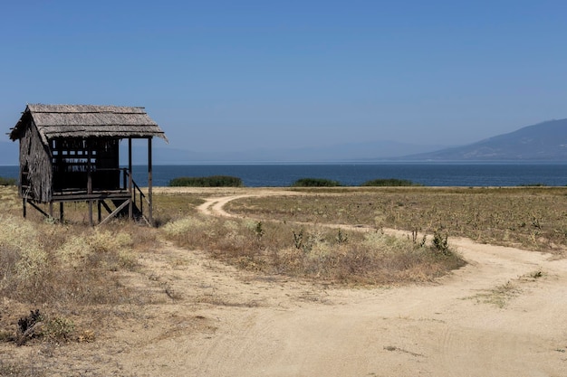 Panorama of a mountain lake Great Prespa and bird watching hut in nom Florina on a sunny day Macedonia northwest Greece